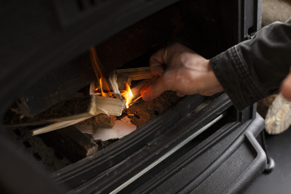 homme allumant cheminee bois hetre